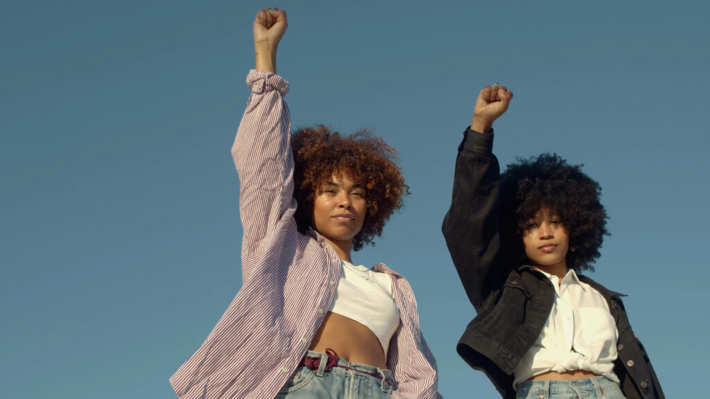 Two women raising their fists at a civil rights demonstration